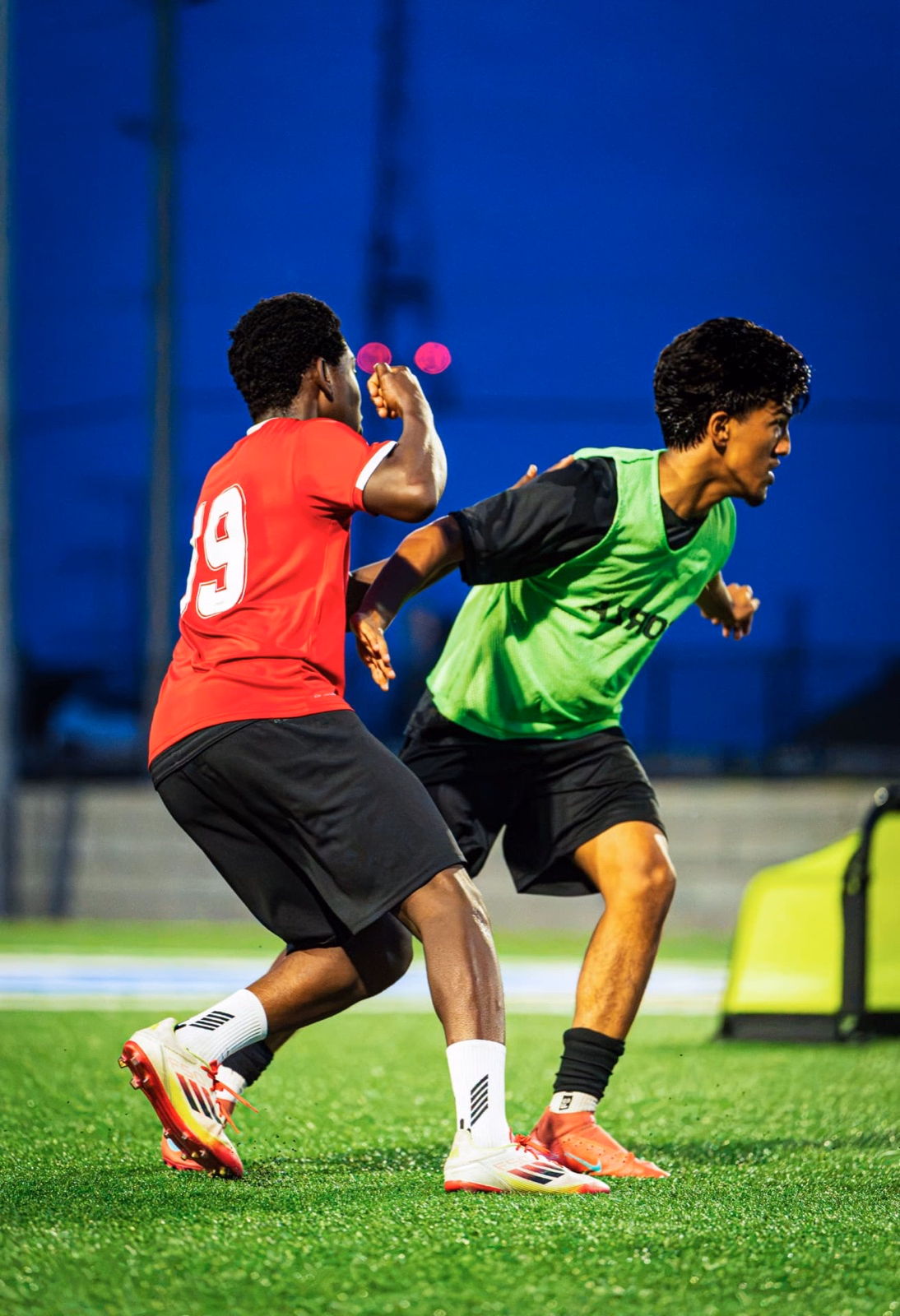 Two Lakeshore United FC players duelling under floodlights