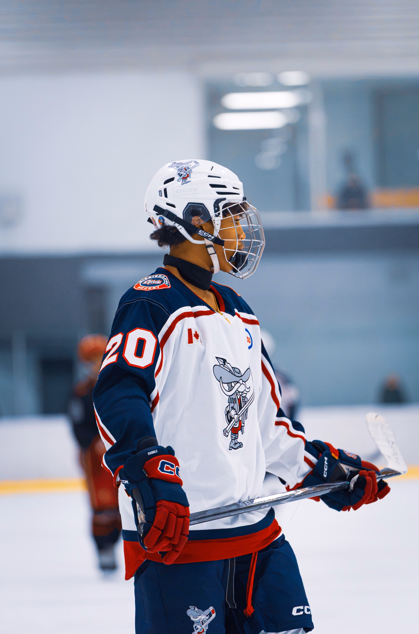 Rebels AAA hockey player wearing number 20 holding a stick on the ice