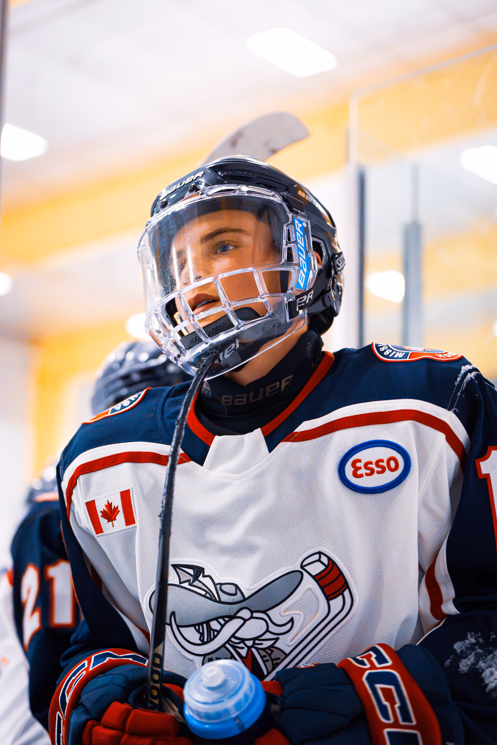 Close-up of a Rebels AAA hockey player wearing a helmet and holding a water bottle